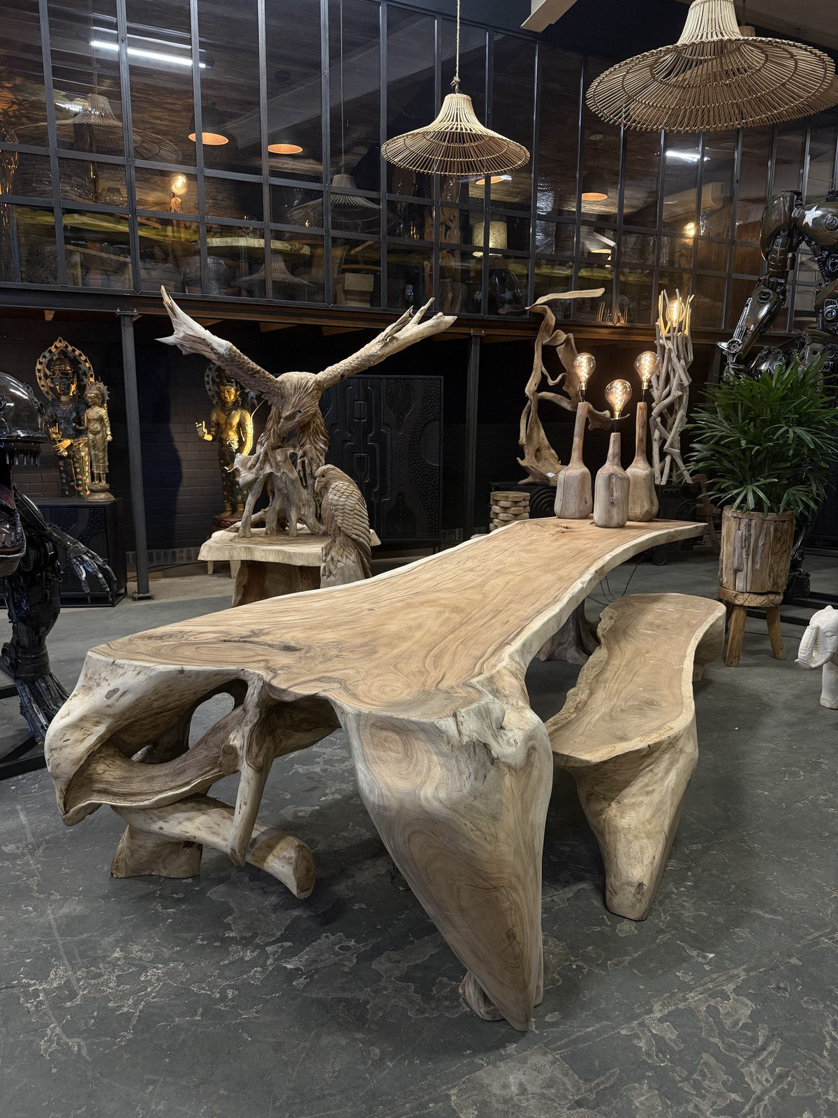 Showroom van Brosi Interiors met boomstamtafels en sculpturen