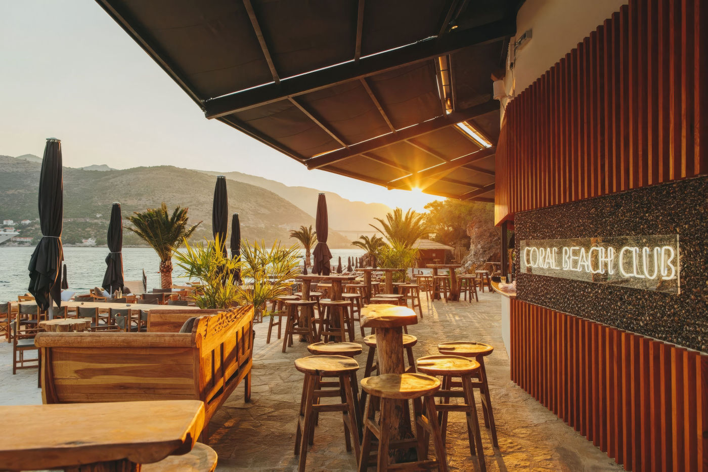 Terras van Coral Beach Club in Dubrovnik met houten meubels