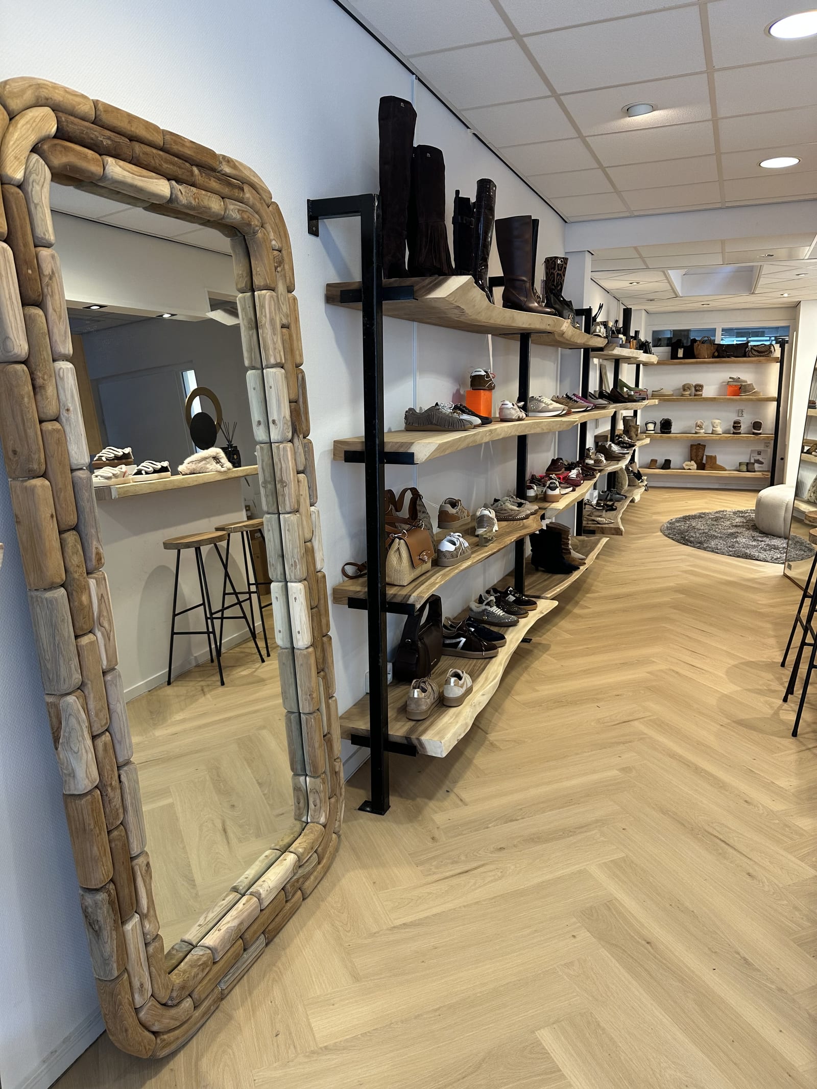 Arunja-spiegel naast de wandrekken in de schoenenwinkel