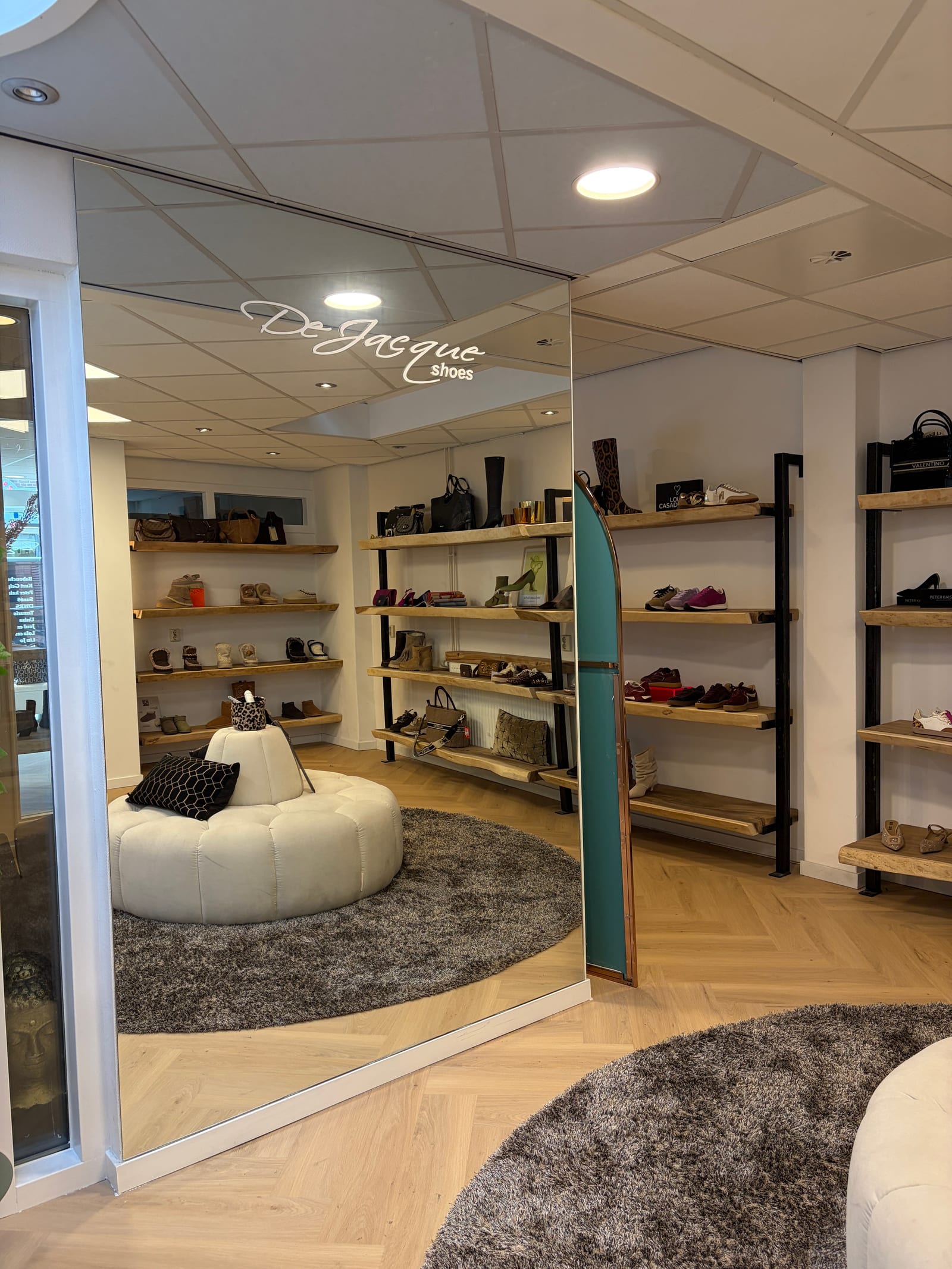 Zithoek met spiegelwand in de schoenenwinkel