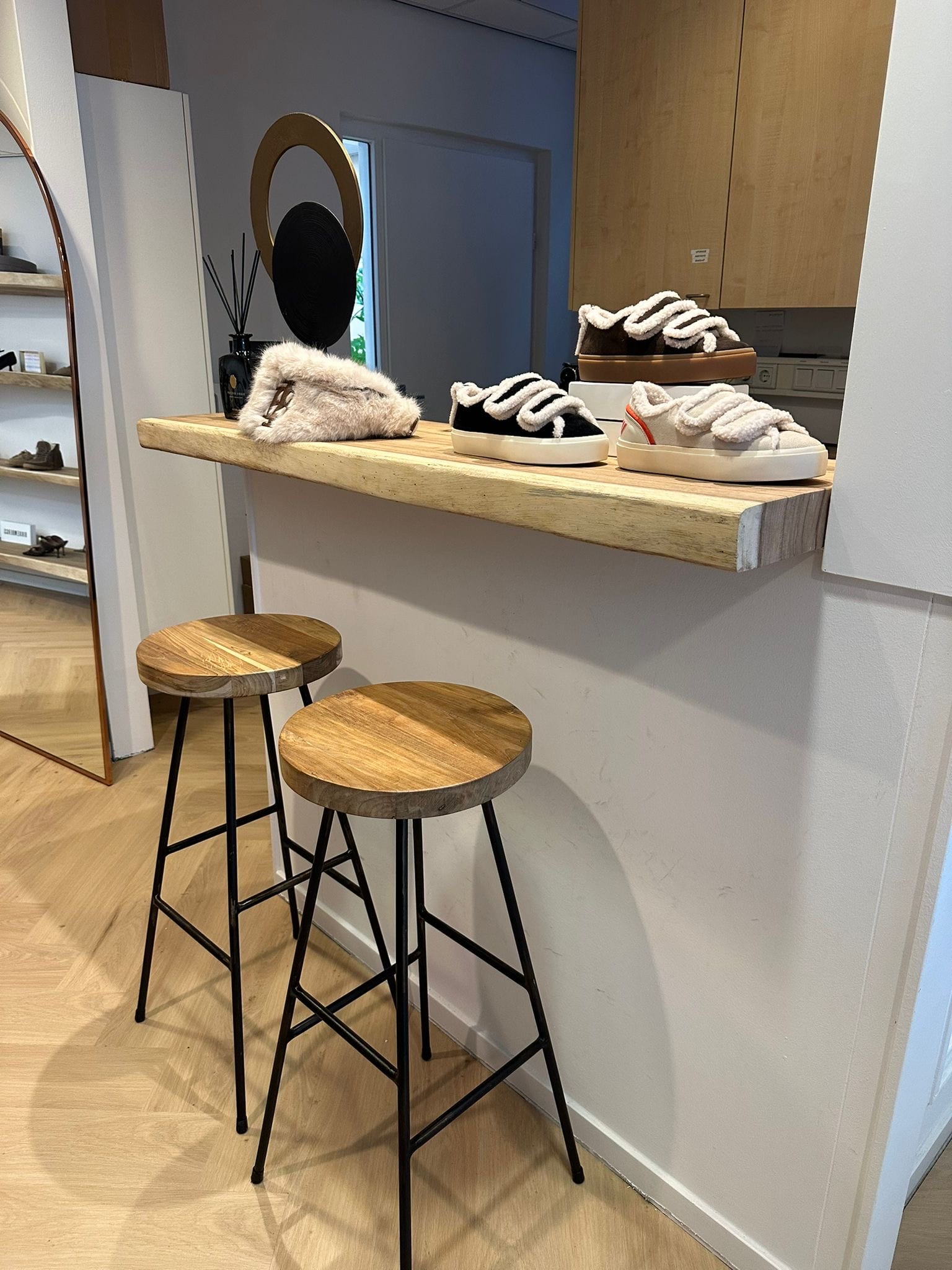 Barkrukken met suar-zitting bij een suar-plank in de schoenenwinkel