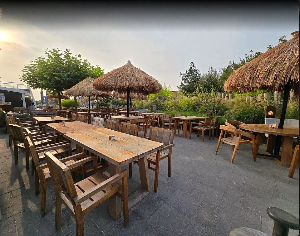 Terras met rieten parasols en houten meubelen